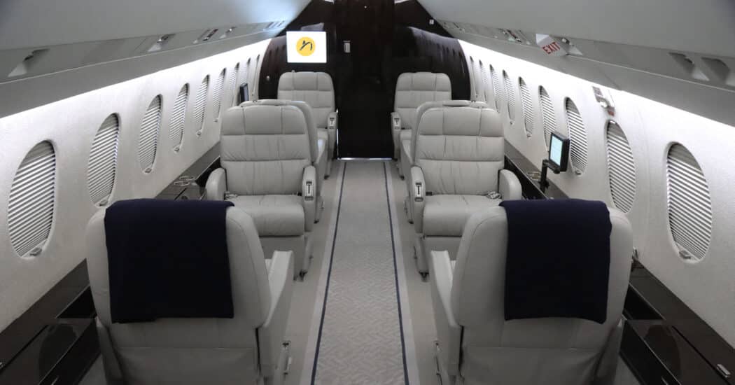 Business Jet Falcon 900 Aircraft interior with grey club seating available for charter.