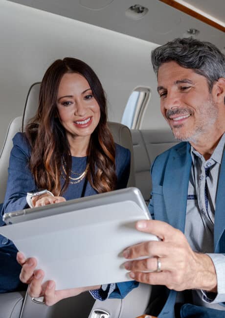 Gogo Branded2 Two passengers on a sleek private jet looking at an iPad