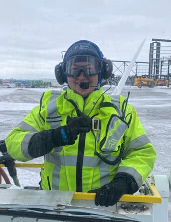 Employee preparing to de-ice an aircraft before takeoff in wintery conditions.