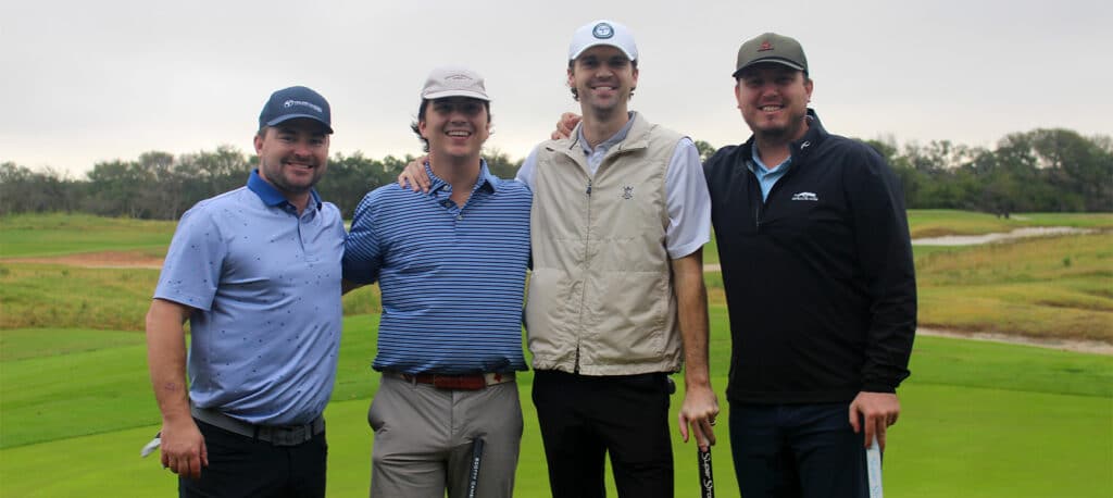 Four golfers standing side-by-side with a lush golf green behind them