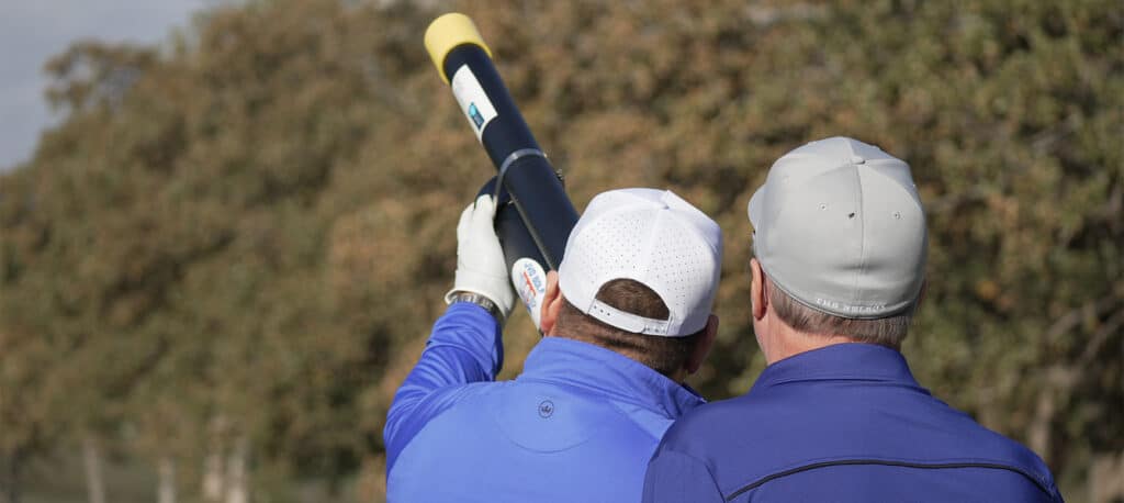 Two Golfers looking at an air canon to lauch their golf ball down the green at the Business Jet Cares Annual Charity Golf Tournament