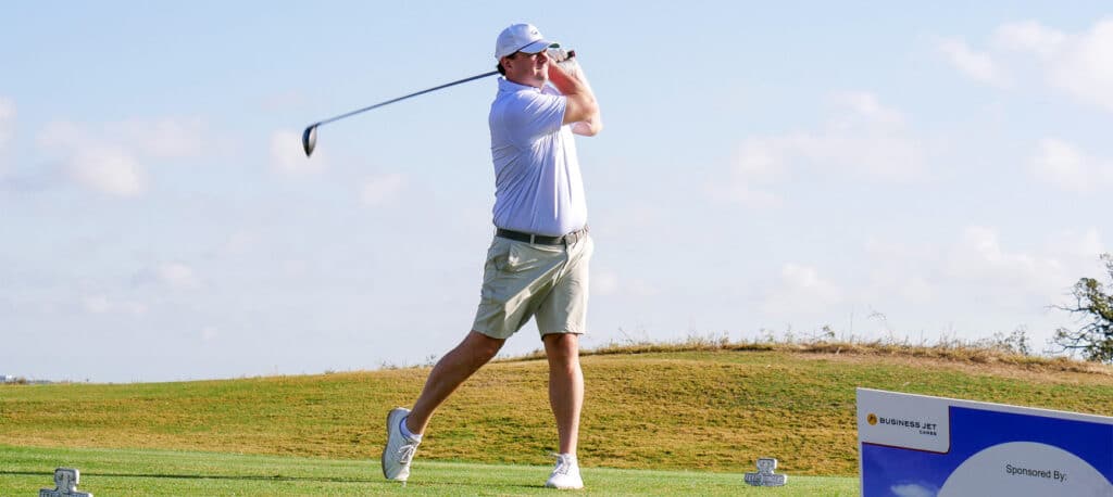 Golfer at the Business Jet Cares Annual Golf Tournament watching the ball fly while still holding the pose from his swing