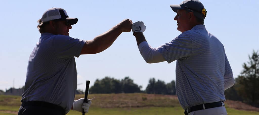 two golfers fist bumping at the Business Jet Cares Annual Charity Golf Tournament