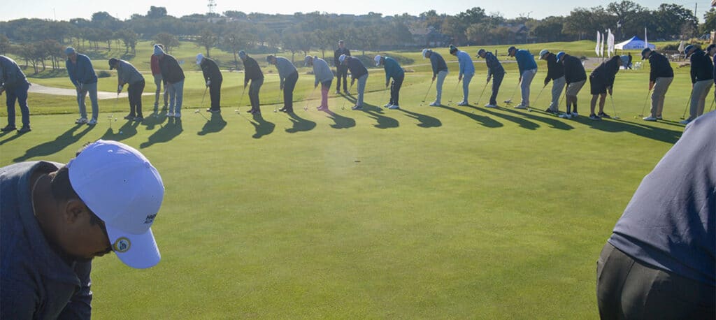 Golfers at the Business Jet Cares Charity Golf Tournament lined up around to see who can putt the closest
