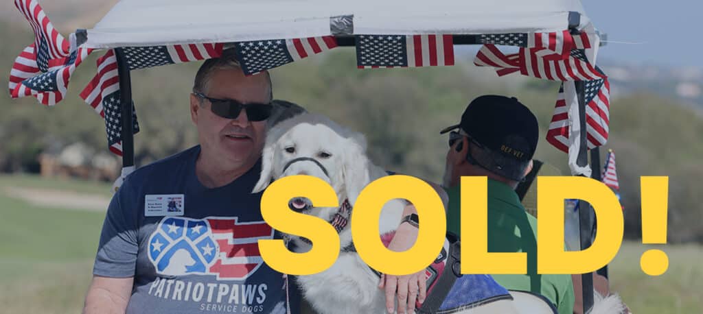 Man on a golf cart with a puppy with SOLD written across the image