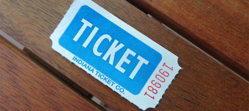 a blue raffle ticket sits on a wooden background