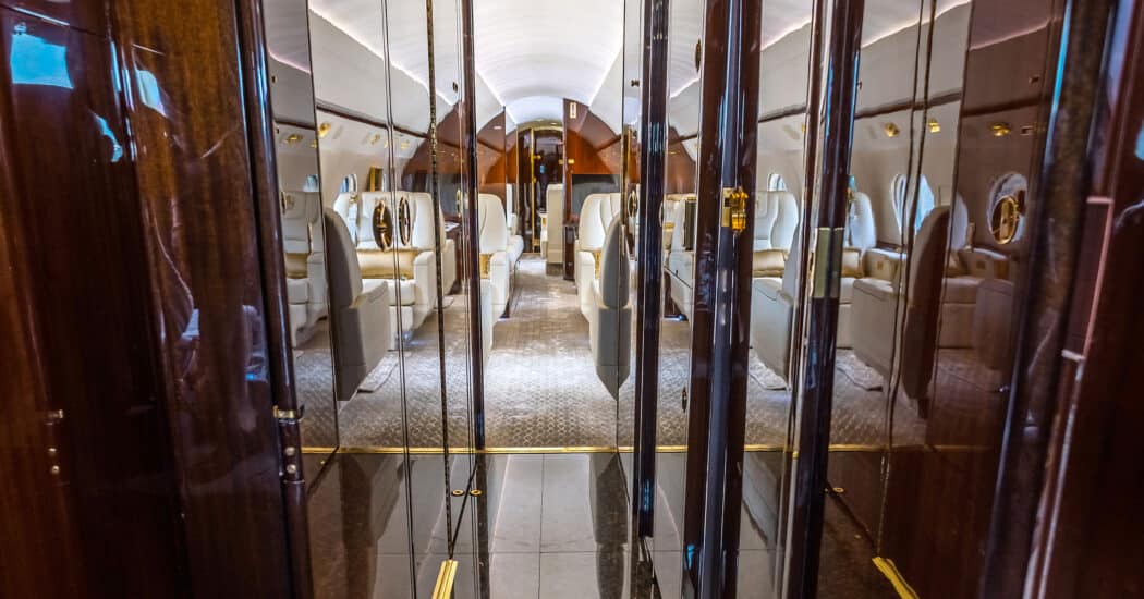 Gulfstream G550 entrance featuring dark wood cabinetry and crew spaces